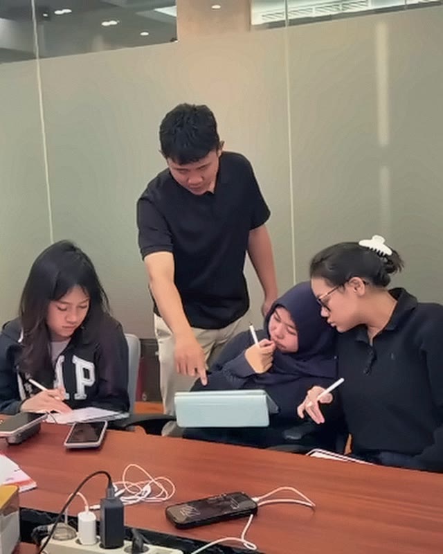 The tutor answers a student's question at her desk